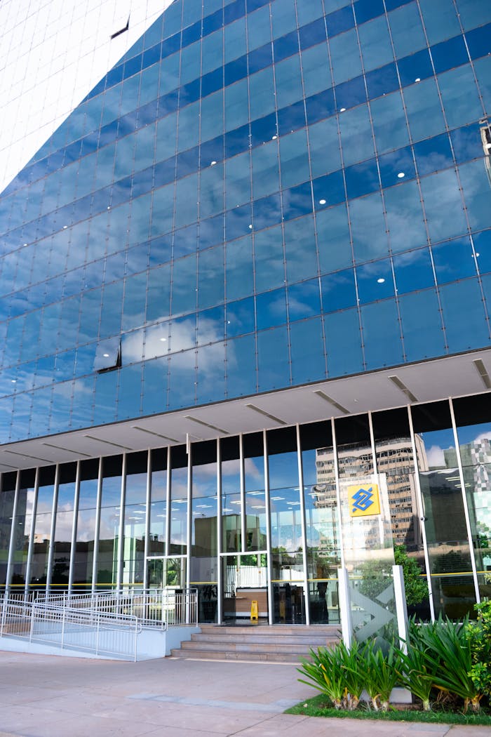 Contemporary glass facade of a building in Brasília reflecting the sky. Vertical composition captures urban architecture.